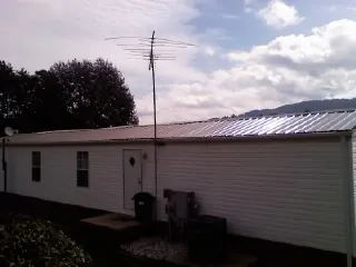 New metal roof on a single wide mobile home with a TV antenna in Kirkland